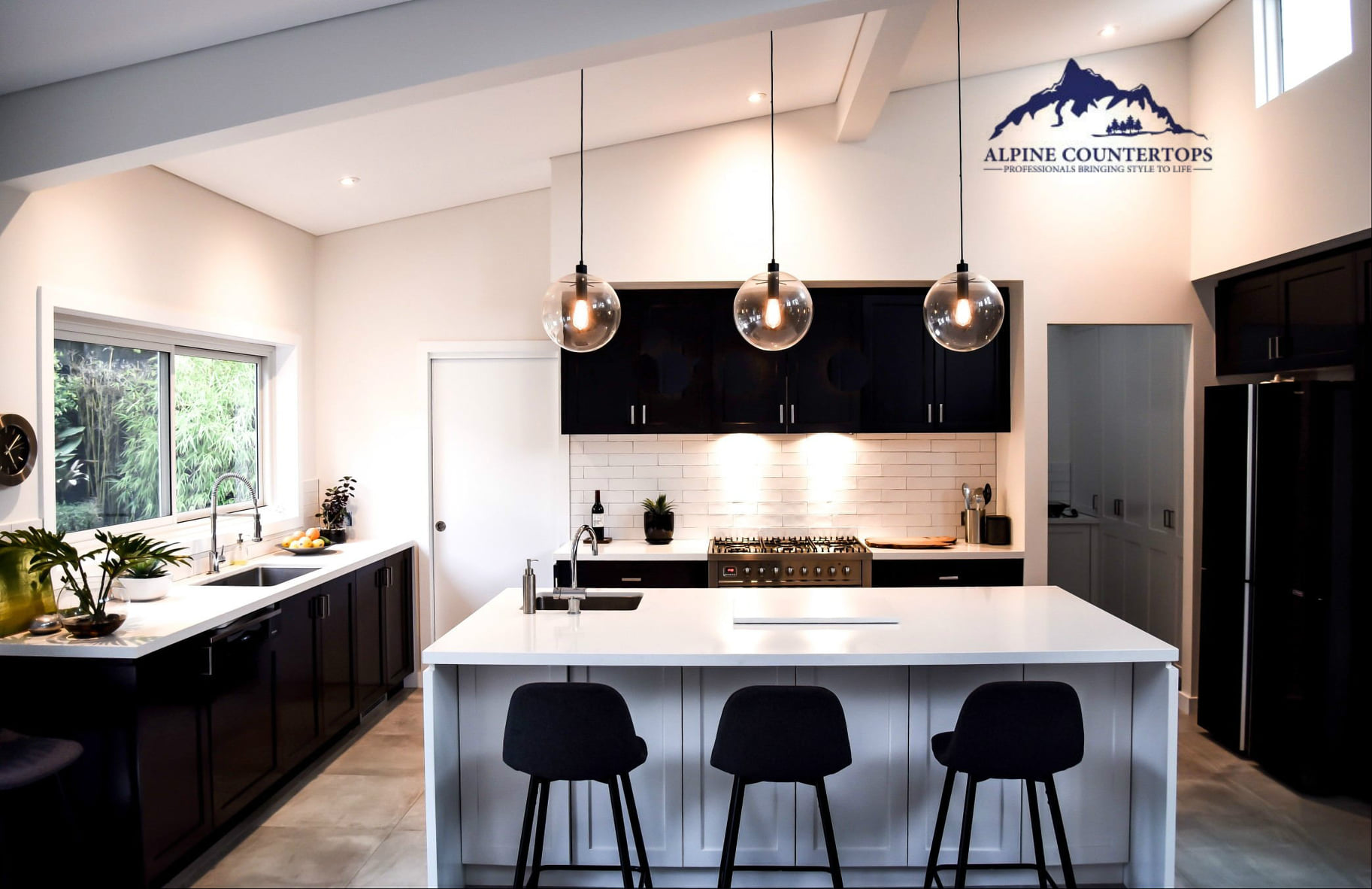 Pale island, black cabinets and three glass pendants