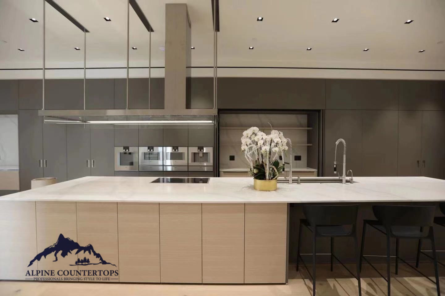 A light stone island with dark cabinetry
