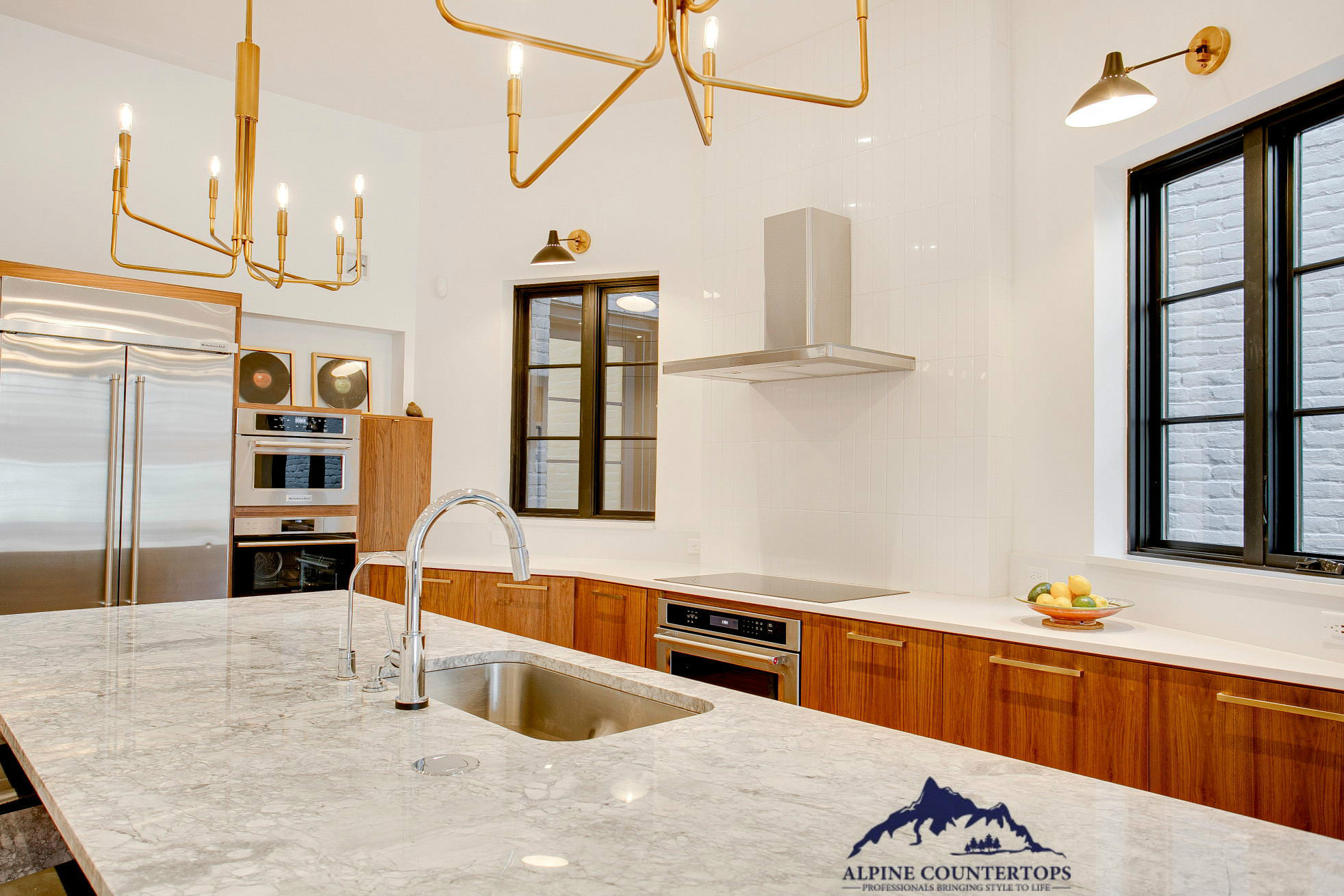 Wood cabinets, warm metal lights and a patterned island