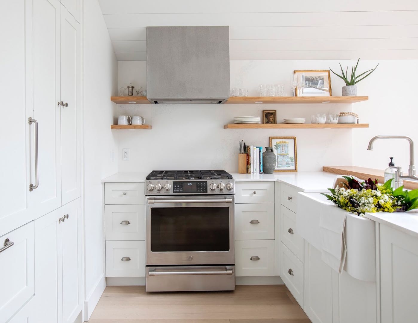 White kitchen with pale counters and open wood shelves